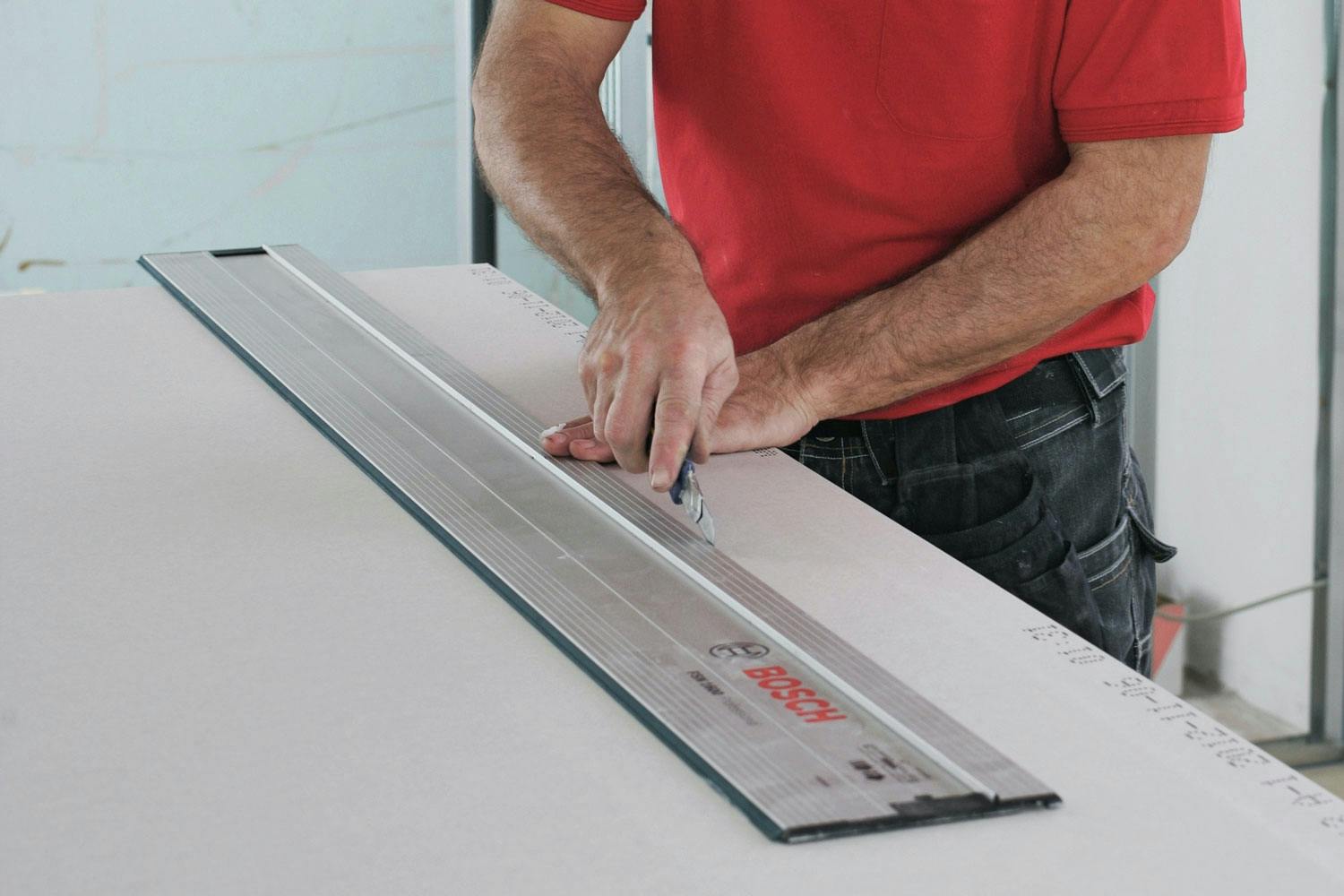 Du har brug for en god lineal, når du skærer gipsplader til. En føringsskinne er super.